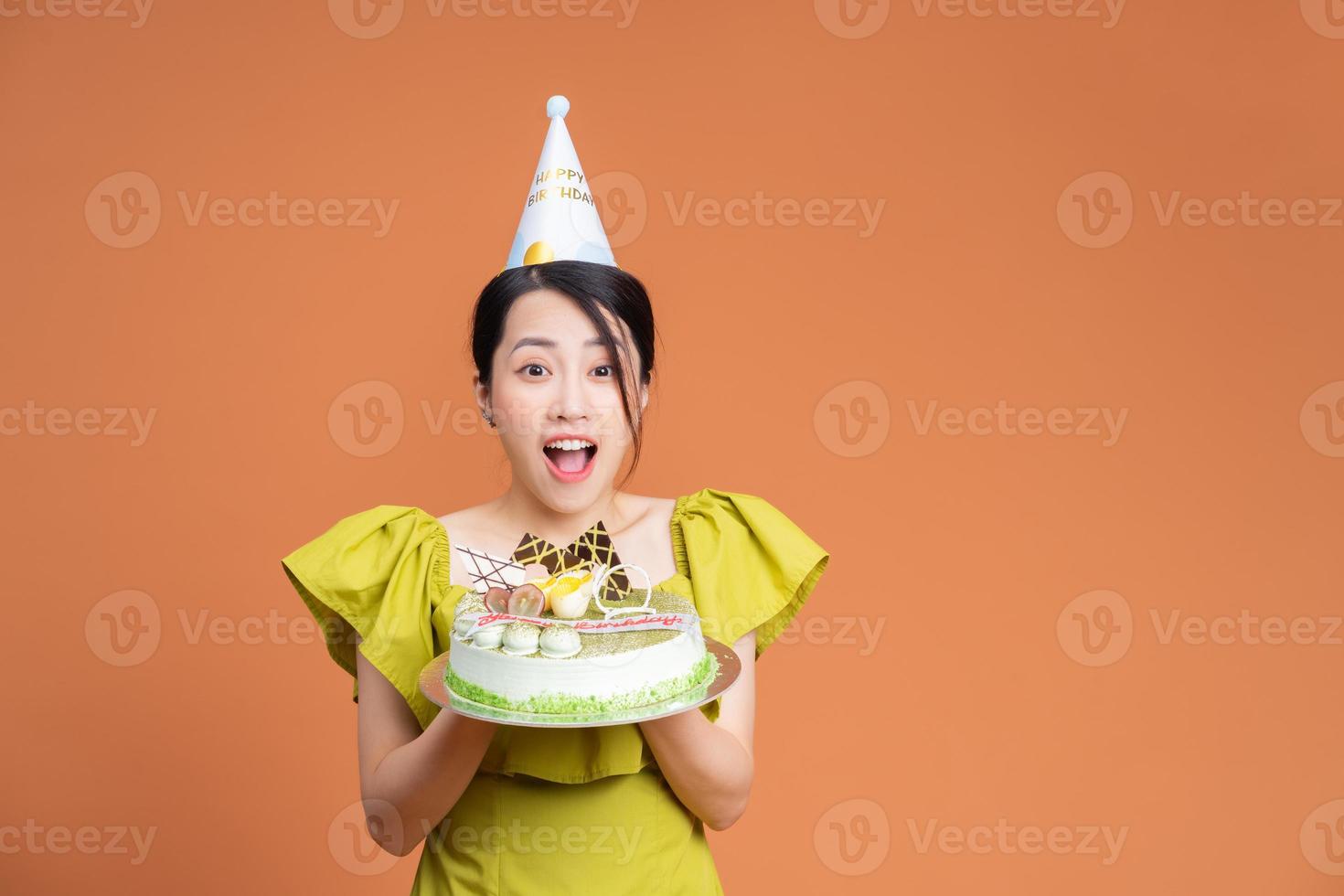 giovane asiatico donna Tenere compleanno torta foto