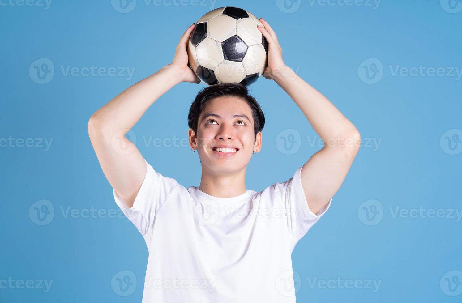 giovane asiatico uomo Tenere palla su sfondo foto