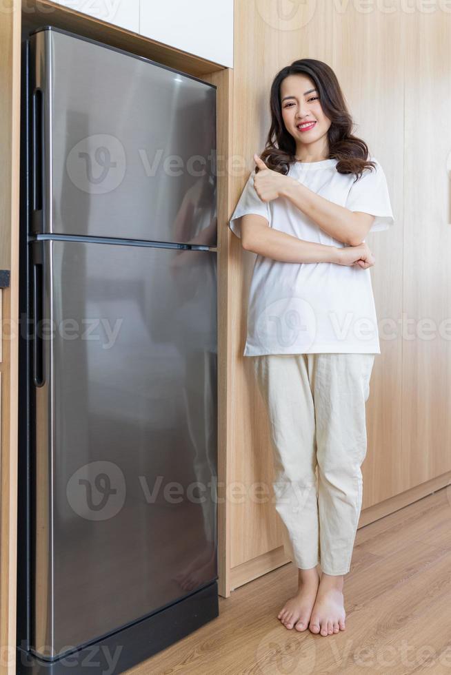 Immagine di giovane asiatico donna con frigo foto