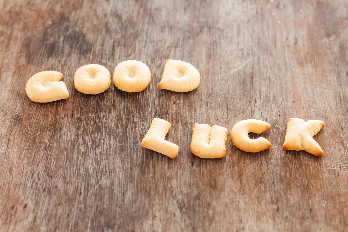 biscotti di alfabeto di buona fortuna su un tavolo di legno foto