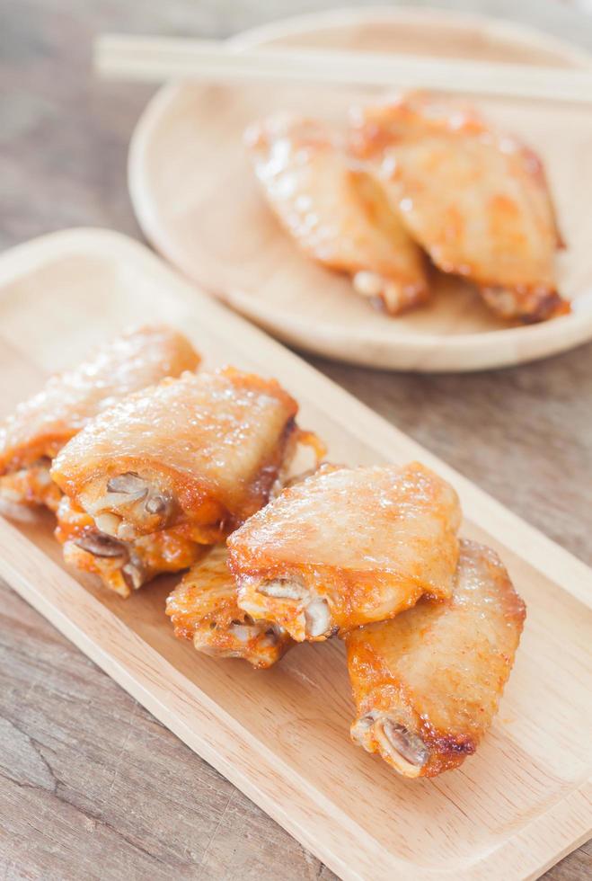 ali di pollo alla griglia su un piatto di legno foto