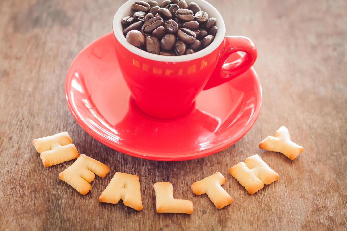 biscotti alfabeto sano con una tazza di caffè rossa foto