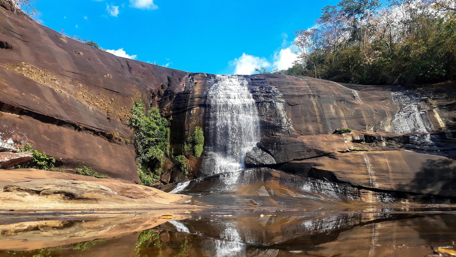 cascate che sgorgano da alti strati di roccia foto