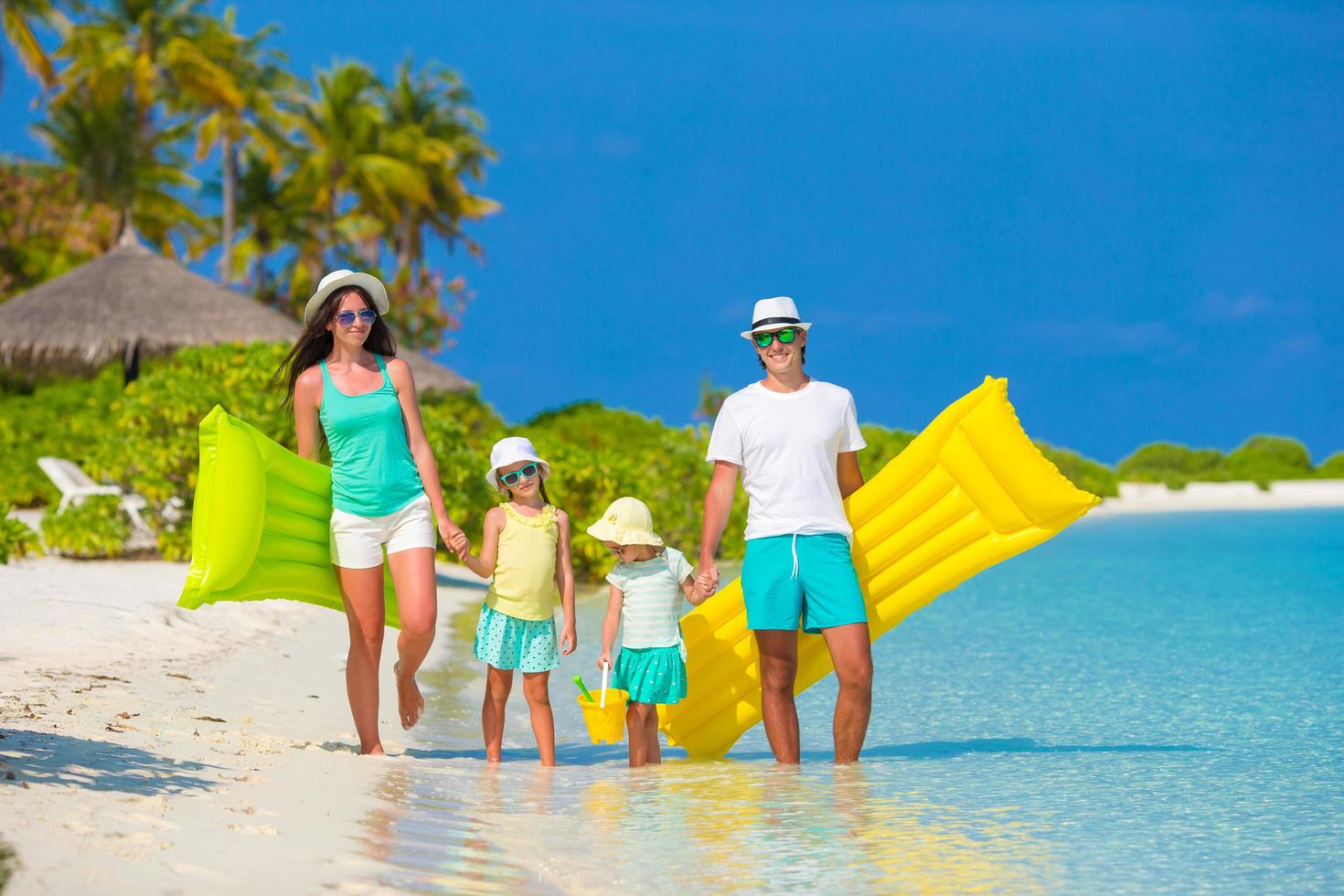 famiglia che cammina su una spiaggia tropicale foto