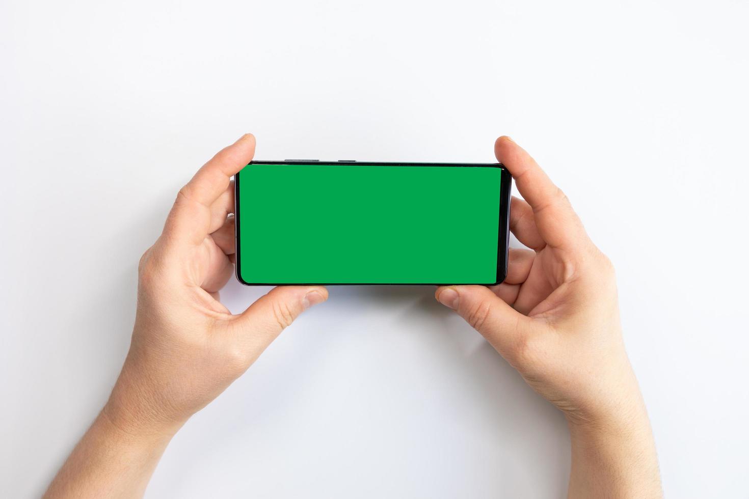 donna in possesso di un telefono cellulare con schermo verde con uno sfondo bianco foto