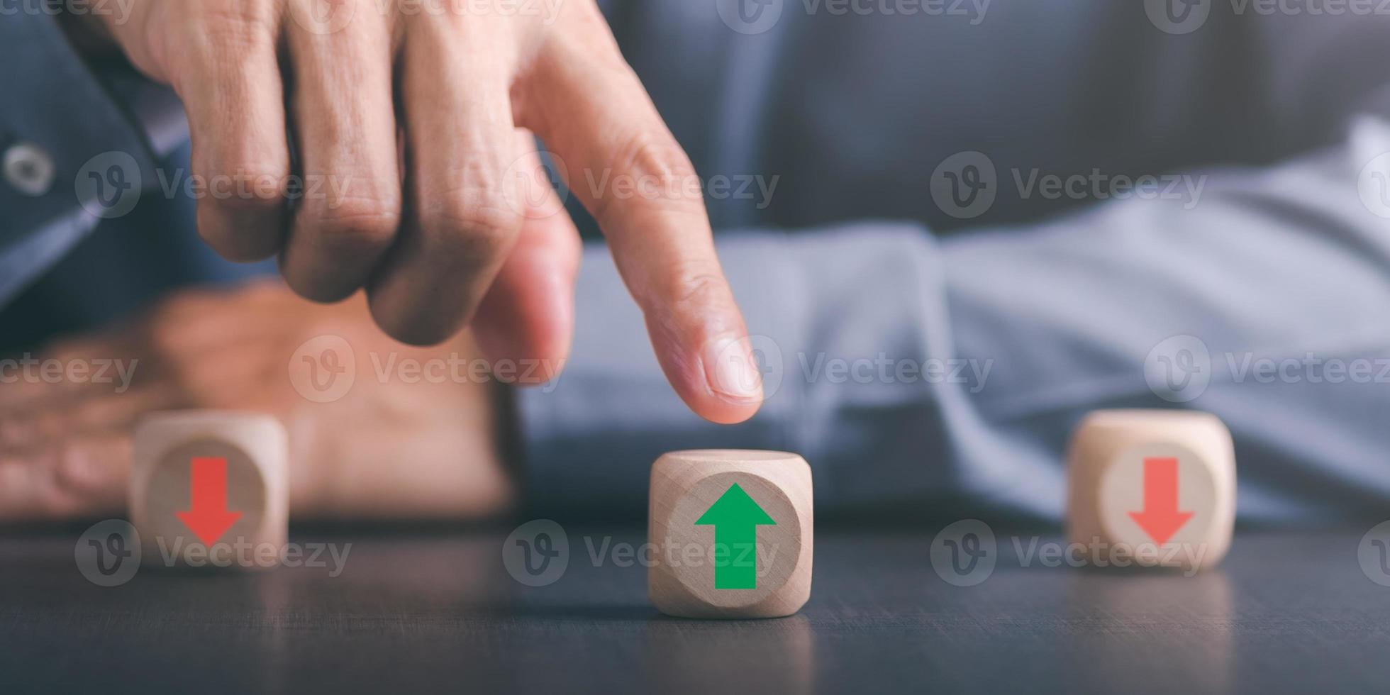 giovane uomo d'affari Selezione di legno blocchi con verde frecce e diverso indicazioni comando concetto e crescita di attività commerciale concorrenza mutevole strategico visione per possibilità di successo foto