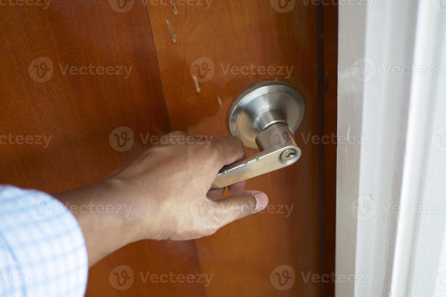 la mano dell'uomo apre la porta da vicino foto