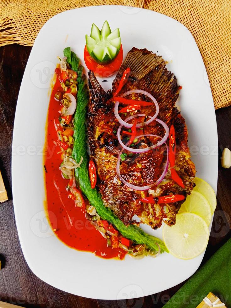 in profondità fritte Tilapia pesce Guarda delizioso su il bianca piatto foto