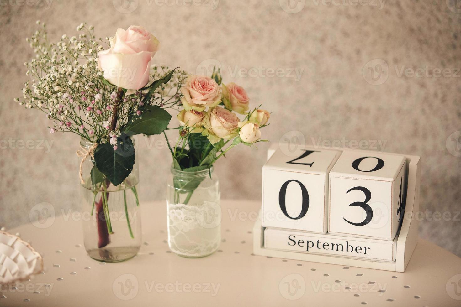 preparativi di mazzi di fiori di fiori di Rose su il tavolo e di legno cubo calendario datato terzo settembre foto