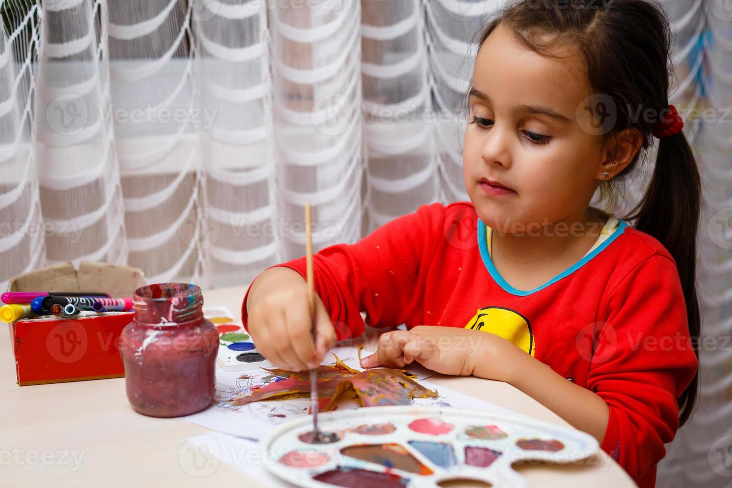 un' giovane bellissimo ragazza è pittura autunno acero foglia foto