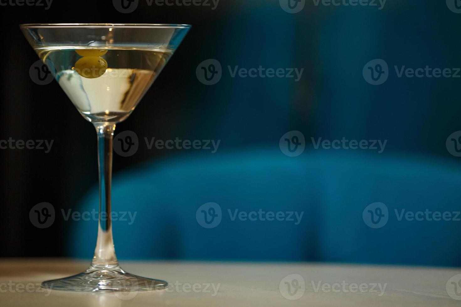 bicchiere con martini, focus su un olive foto