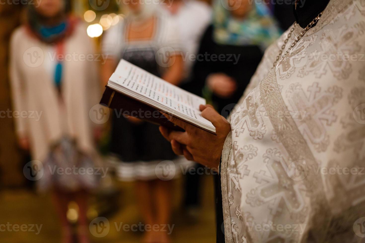 sacerdote mano quello detiene il Bibbia e attraversare foto
