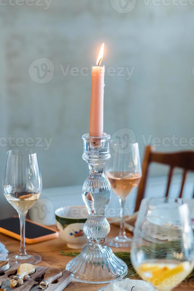 rosa candela nel un' candelabri su un' tavolo avvicinamento con bicchieri di vino e Champagne foto