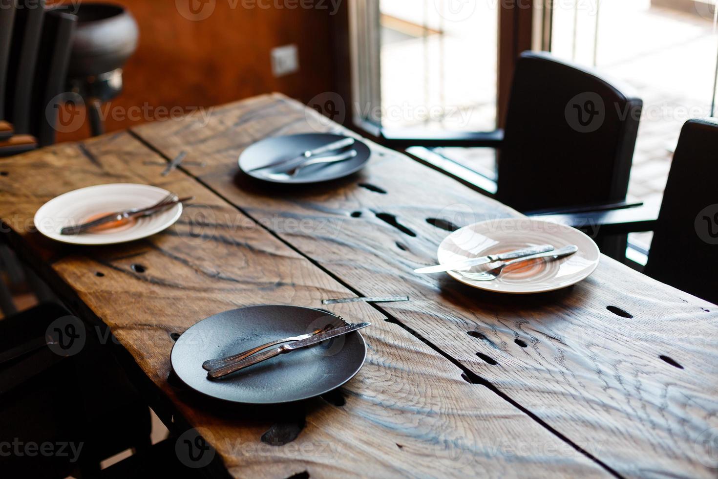 vuoto piatto con coltello e forchetta su Vintage ▾ di legno tavolo foto