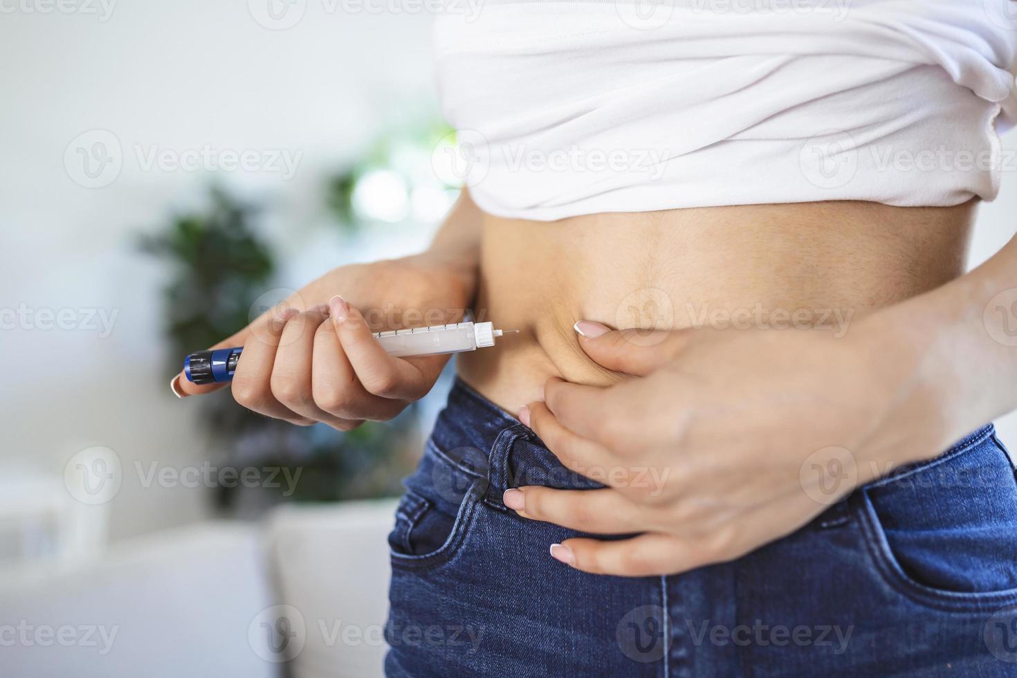 un' diabetico paziente utilizzando insulina penna per fabbricazione un insulina iniezione a casa. giovane donna controllo diabete. diabetico stile di vita foto