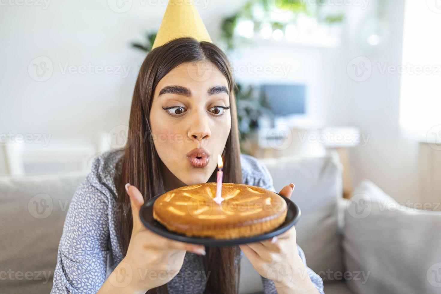 nuovo normale concetto. contento donna festeggiare sua compleanno solo. giovane donna Tenere un' torta. compleanno festa a casa. famiglia video chiamata. sociale distanziamento. vita a casa. fabbricazione un' desiderio foto