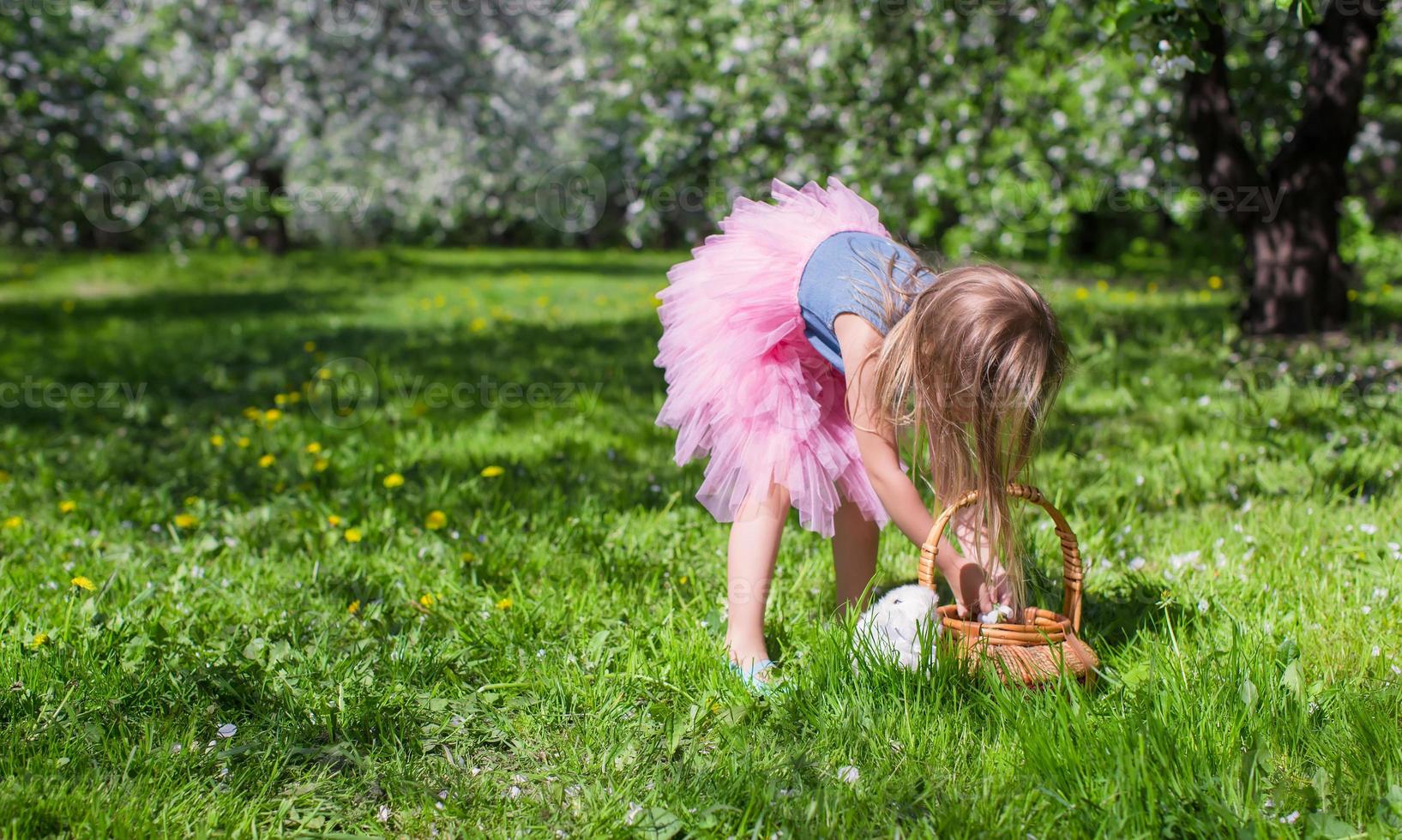 adorabile poco ragazza con cannuccia cestino nel fioritura Mela frutteto foto