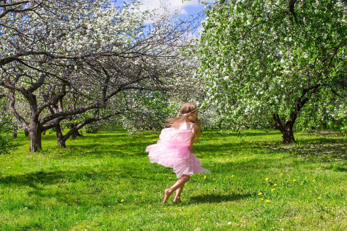 adorabile poco ragazza con farfalla Ali avere divertimento nel fioritura Mela frutteto foto