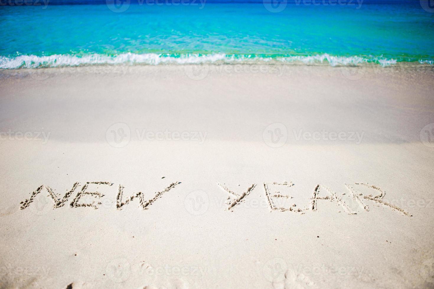 contento nuovo anno scritto nel il bianca sabbia foto