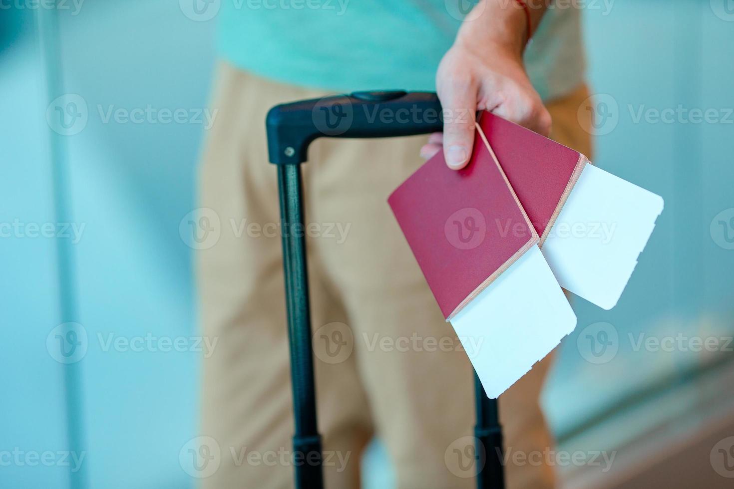 primo piano dell'uomo che tiene i passaporti e la carta d'imbarco all'aeroporto foto