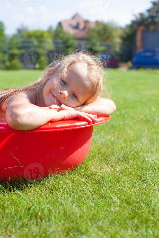 ritratto di sorridente affascinante poco ragazza avere divertimento nel il piscina all'aperto foto