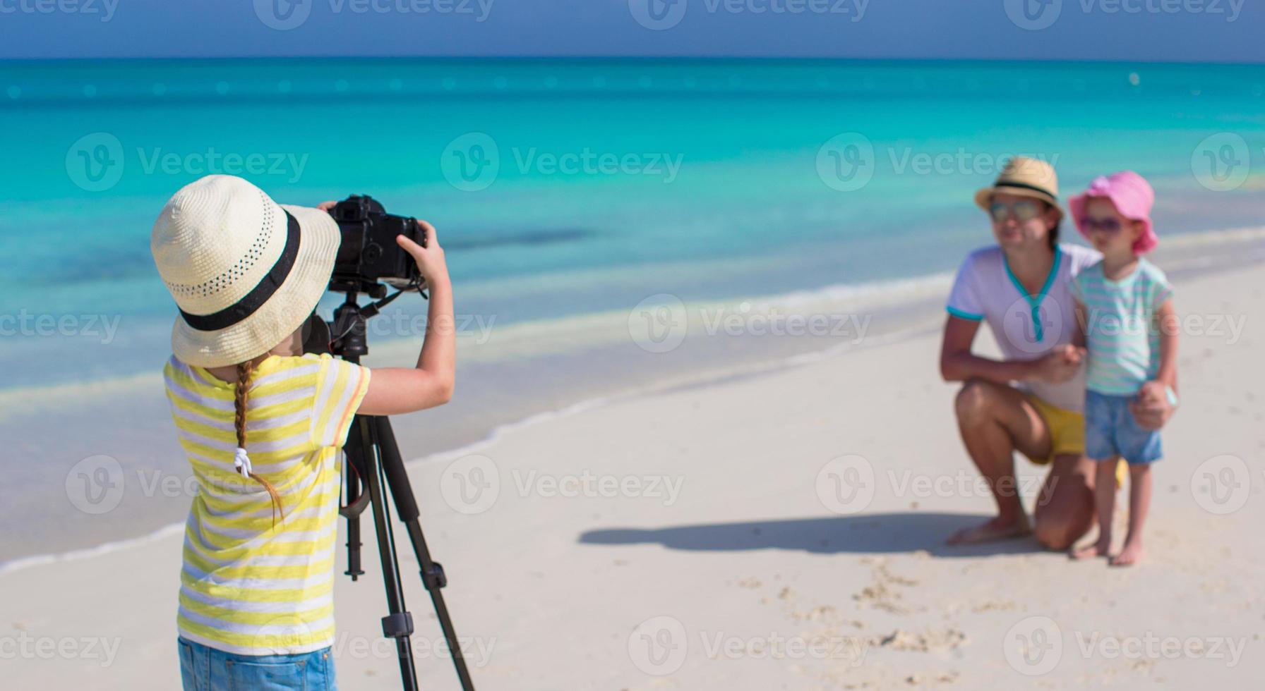 poco ragazza fabbricazione foto di sua papà e sorella a il spiaggia