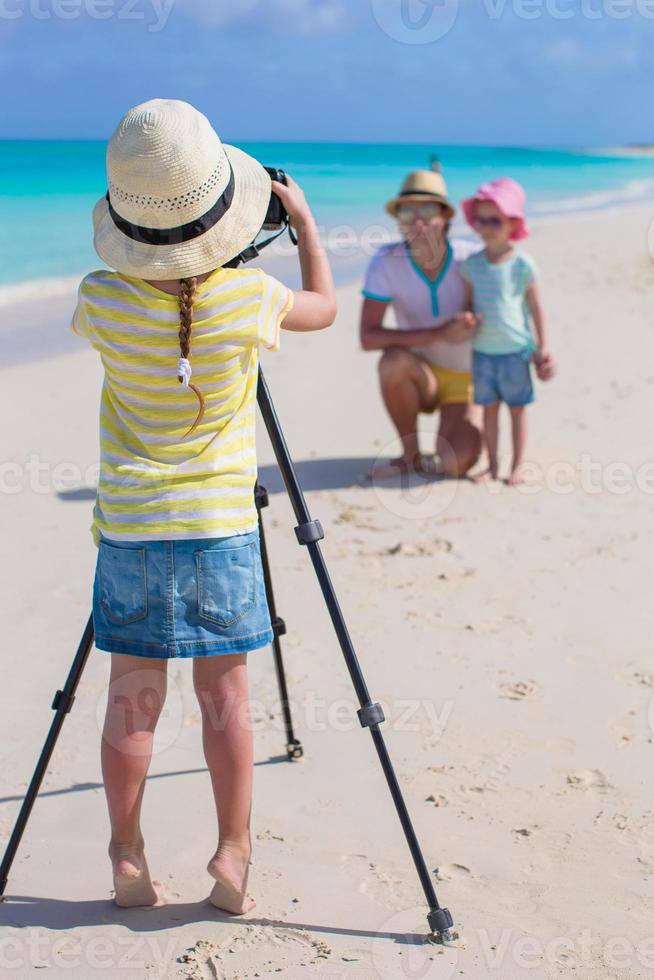 poco ragazza fabbricazione foto di sua papà e sorella a il spiaggia