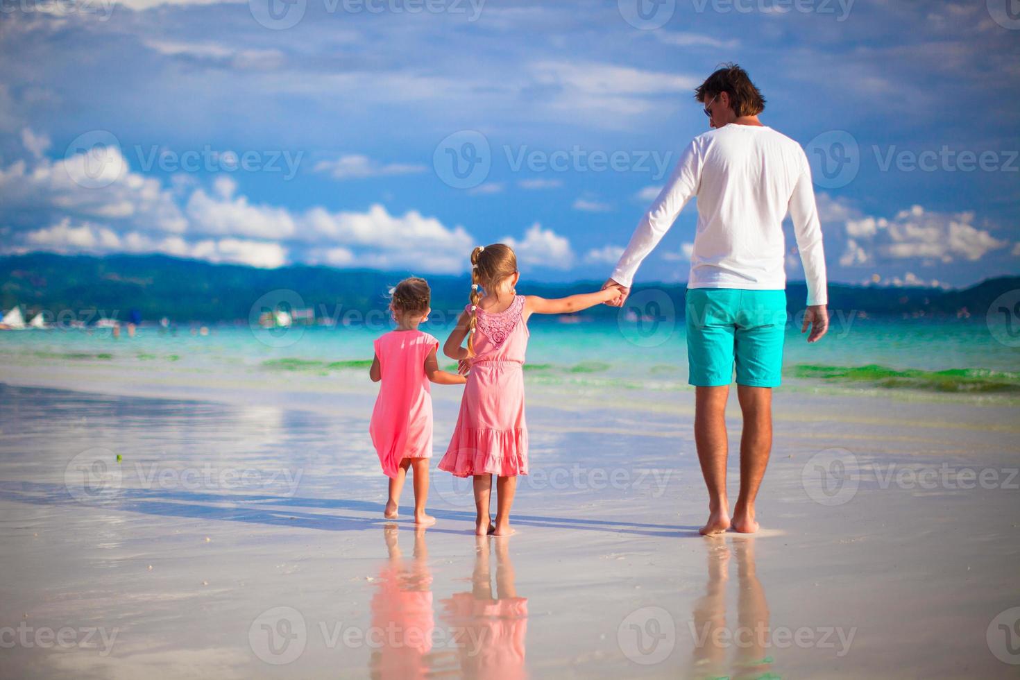 padre e poco ragazze insieme durante tropicale vacanza foto