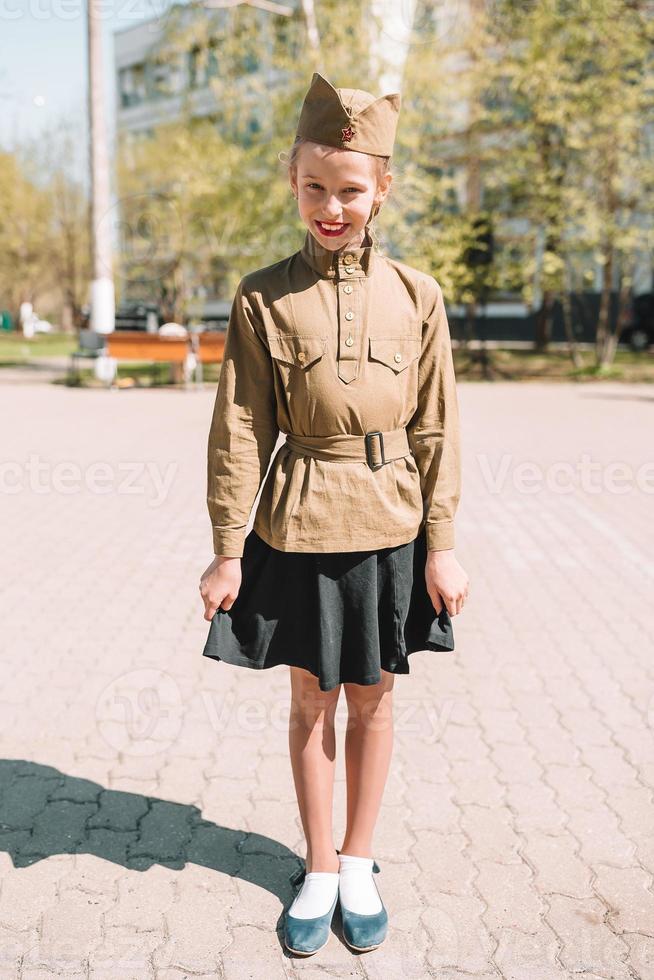 poco ragazza nel militare uniforme su vacanza giorno di vittoria foto