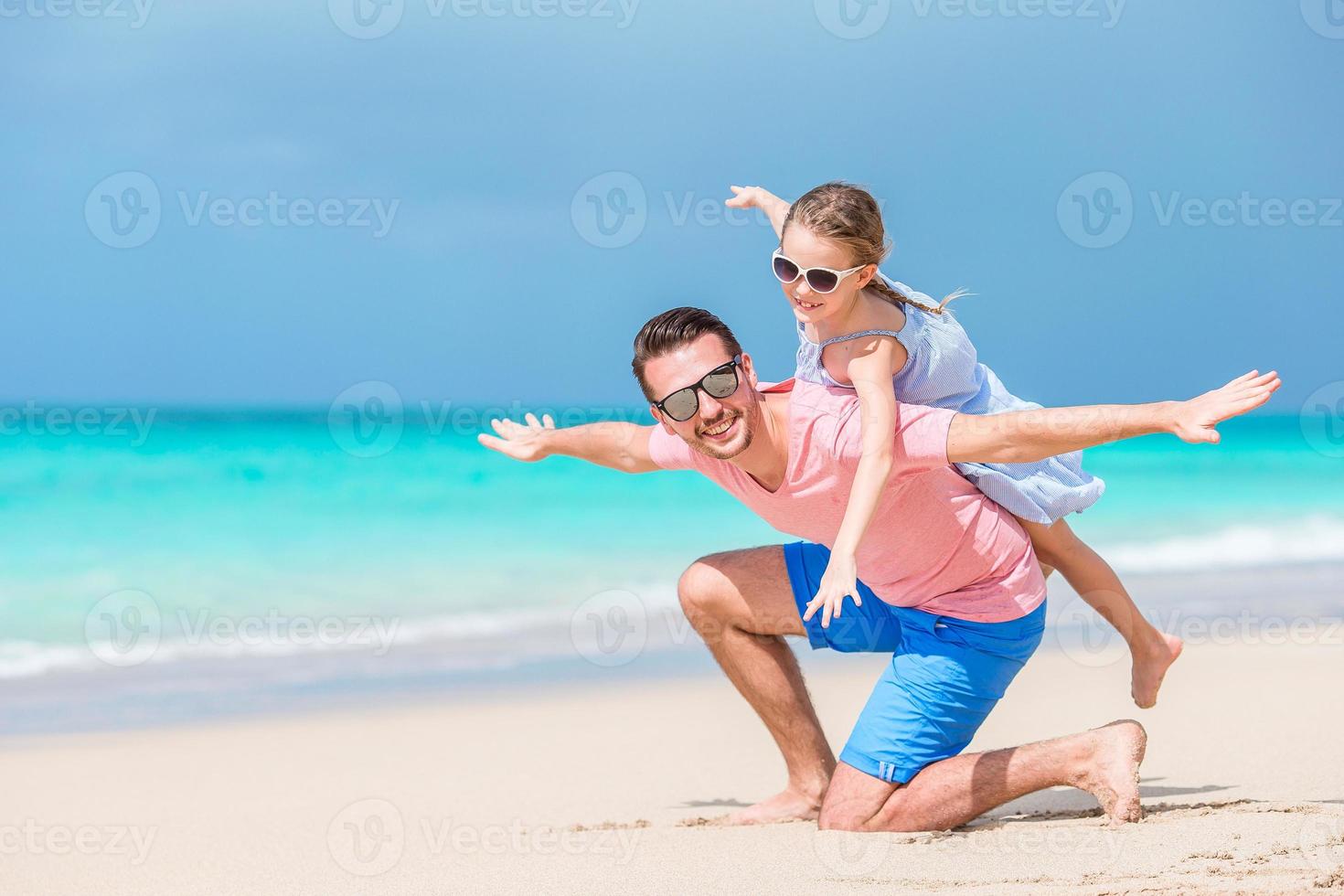 famiglia di padre e sportivo poco ragazza avendo divertimento su il spiaggia foto