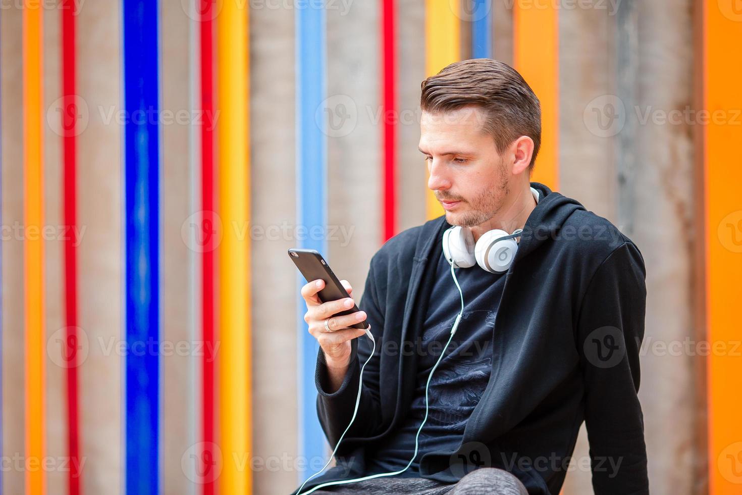 uomo è lettura testo Messaggio su mobile Telefono mentre a piedi nel il parco foto