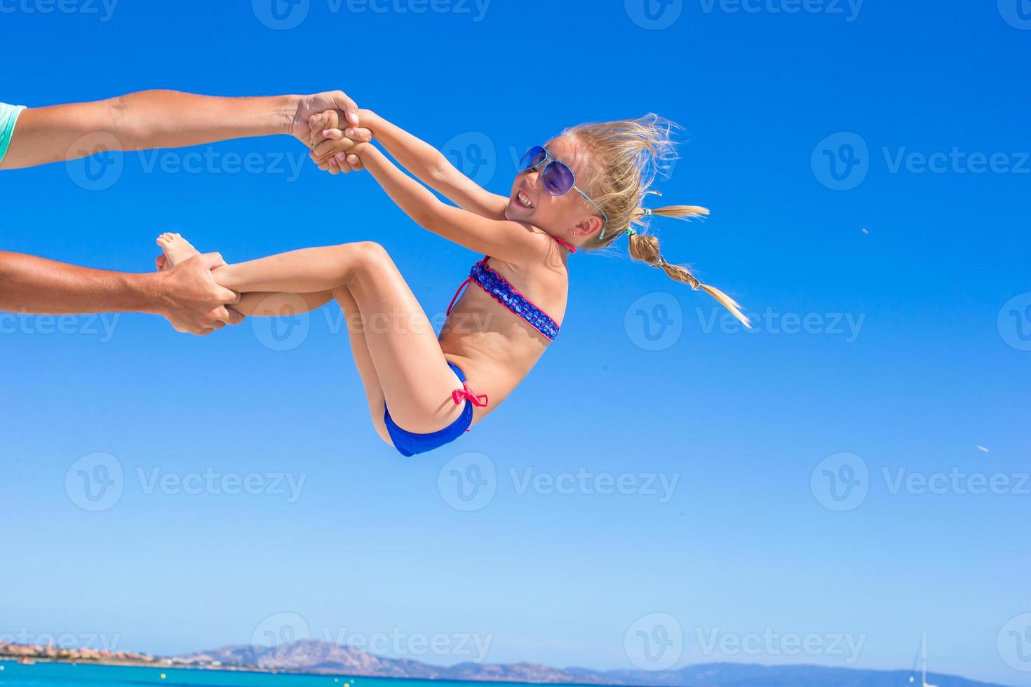 contento poco ragazza avere divertimento con sua papà durante spiaggia vacanza foto