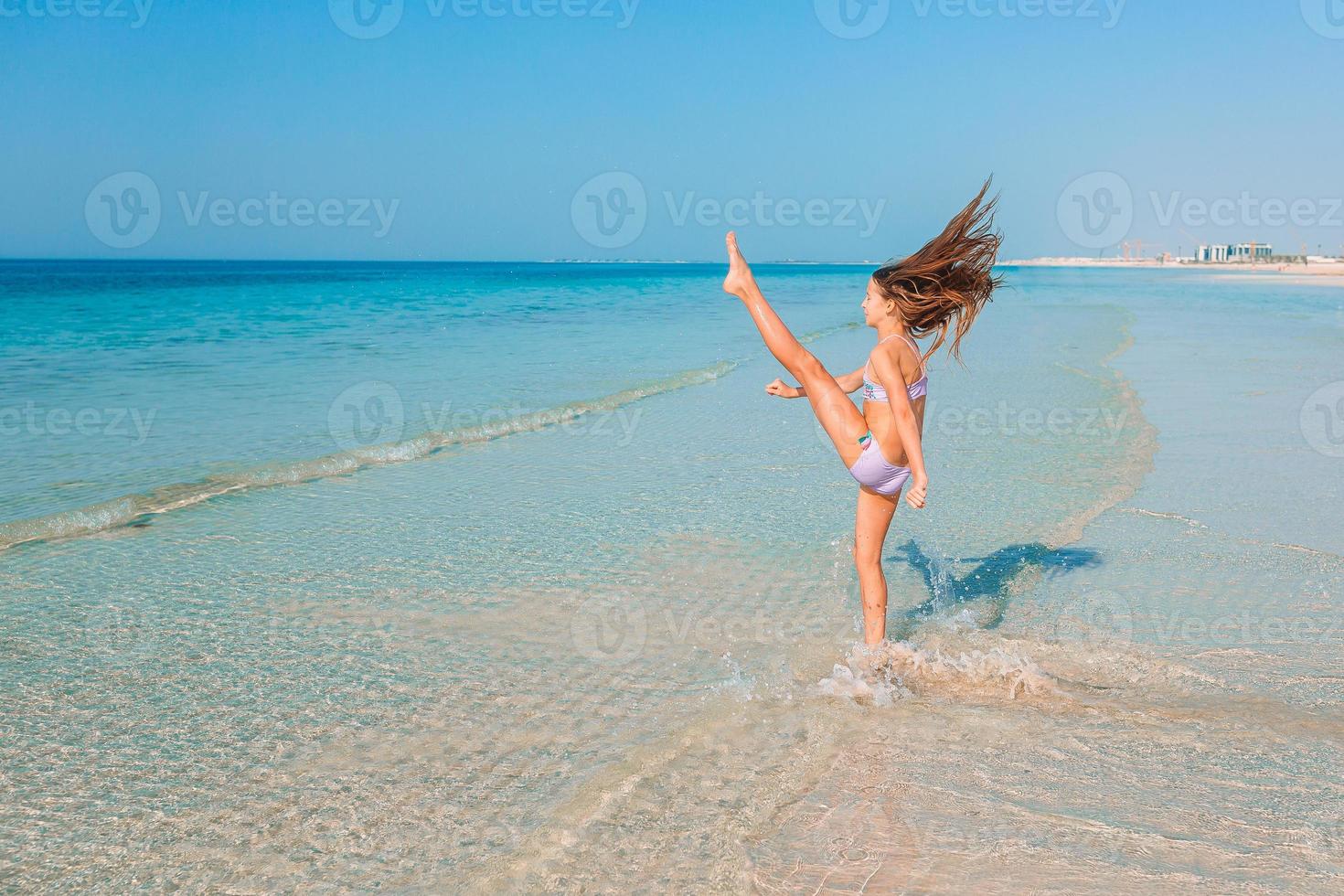 adorabile bambina attiva in spiaggia durante le vacanze estive foto