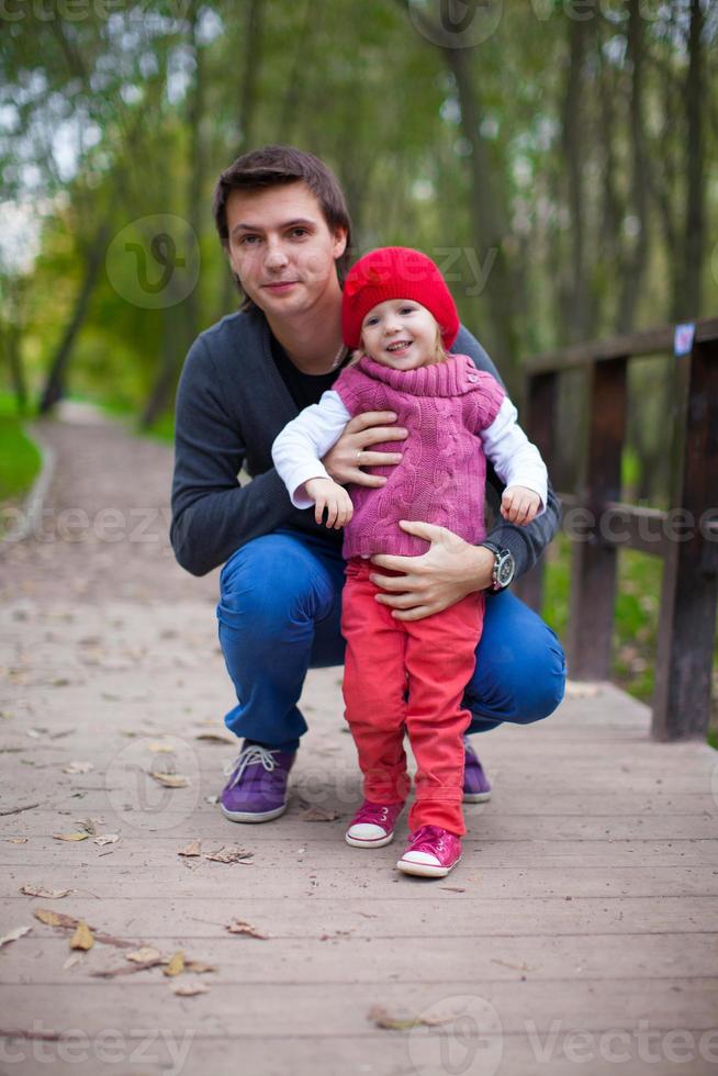 ritratto di contento padre con figlia nel il parco a caldo autunno giorno foto