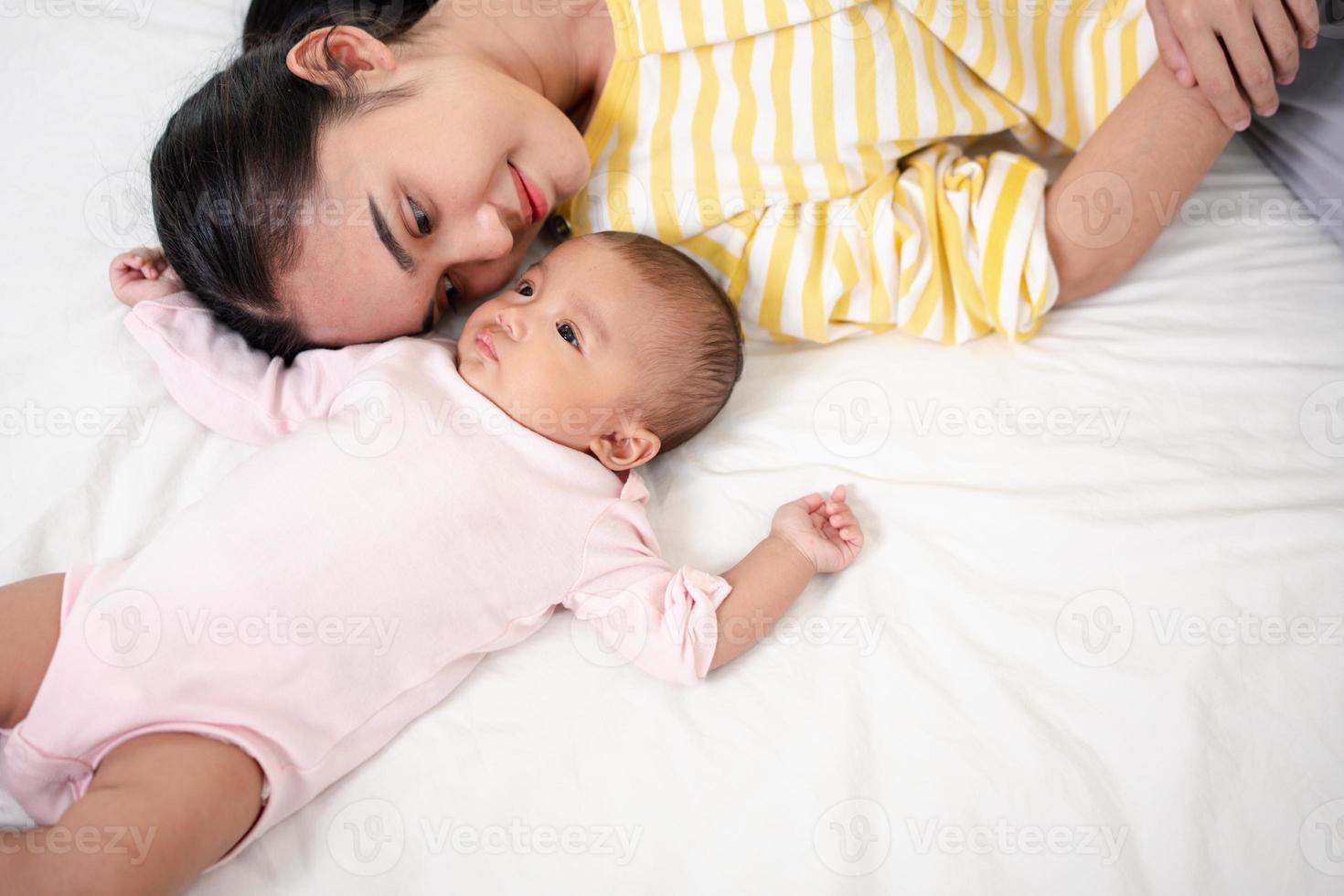 madre genitorialità e neonato nascita vita. mamma e bambino ragazzo giocando nel soleggiato Camera da letto, famiglia avendo divertimento insieme. assistenza all'infanzia, maternità concetto. foto