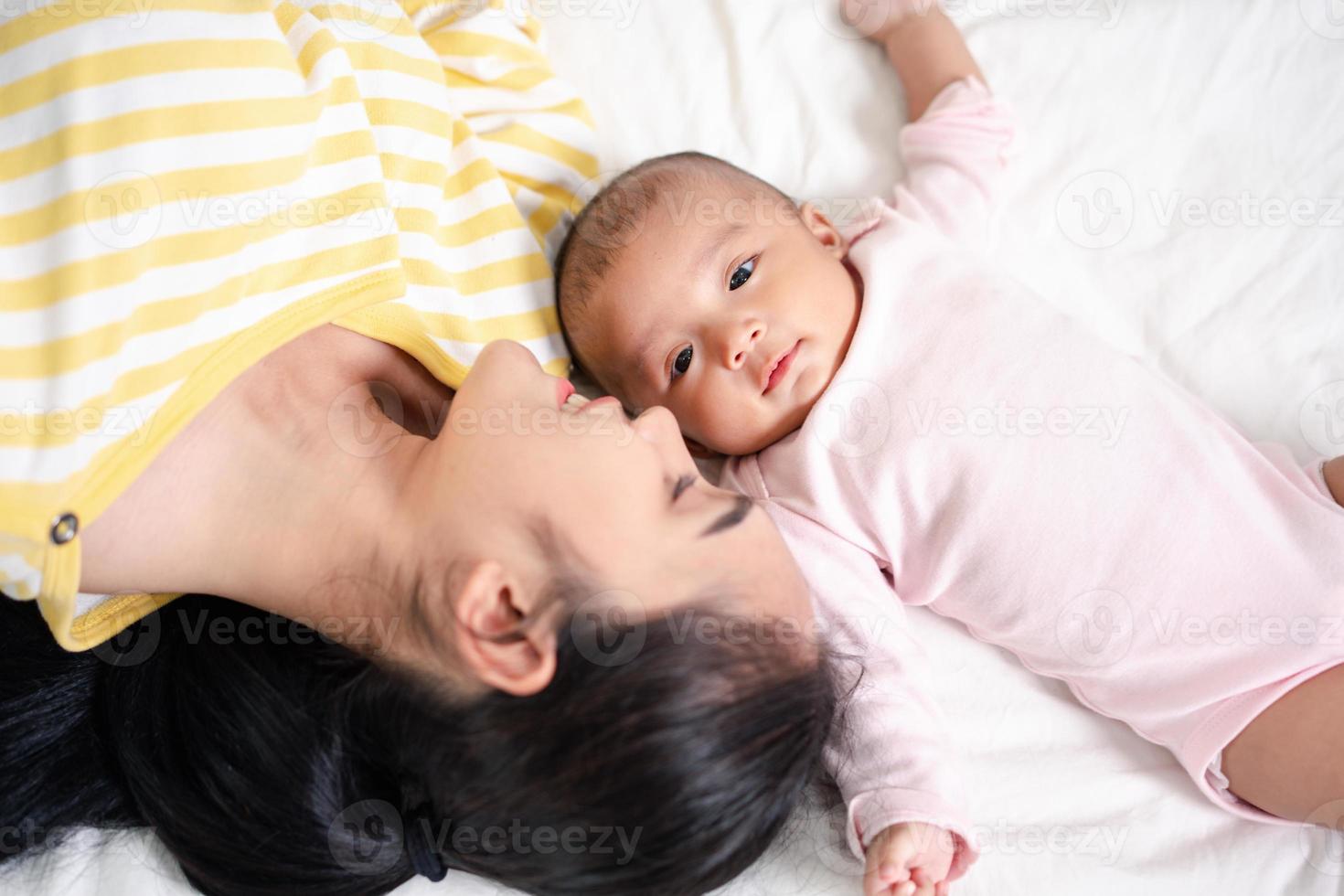 madre genitorialità e neonato nascita vita. mamma e bambino ragazzo giocando nel soleggiato Camera da letto, famiglia avendo divertimento insieme. assistenza all'infanzia, maternità concetto. foto