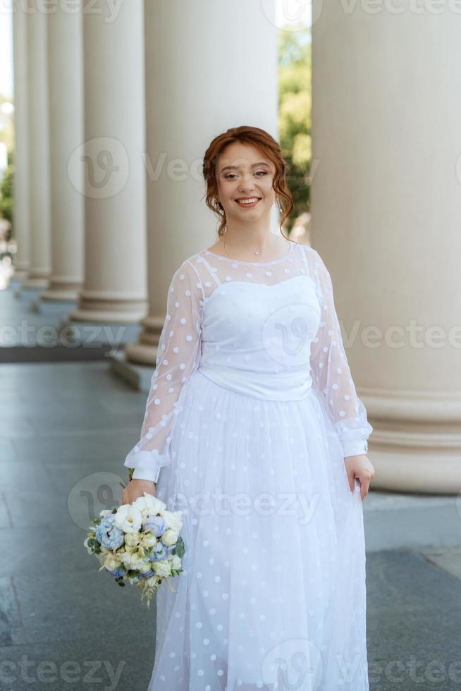 ritratto di un' giovane sposa ragazza nel un' leggero vestito nel un urbano ambiente foto