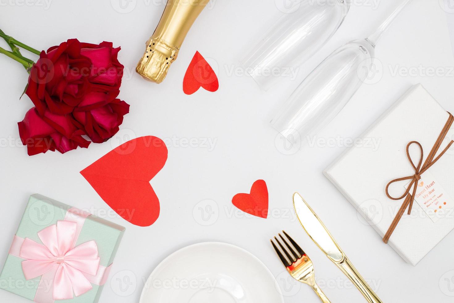 San Valentino giorno concetto, Champagne e rosa su il tavolo con bicchiere posate e regalo scatola per cena foto