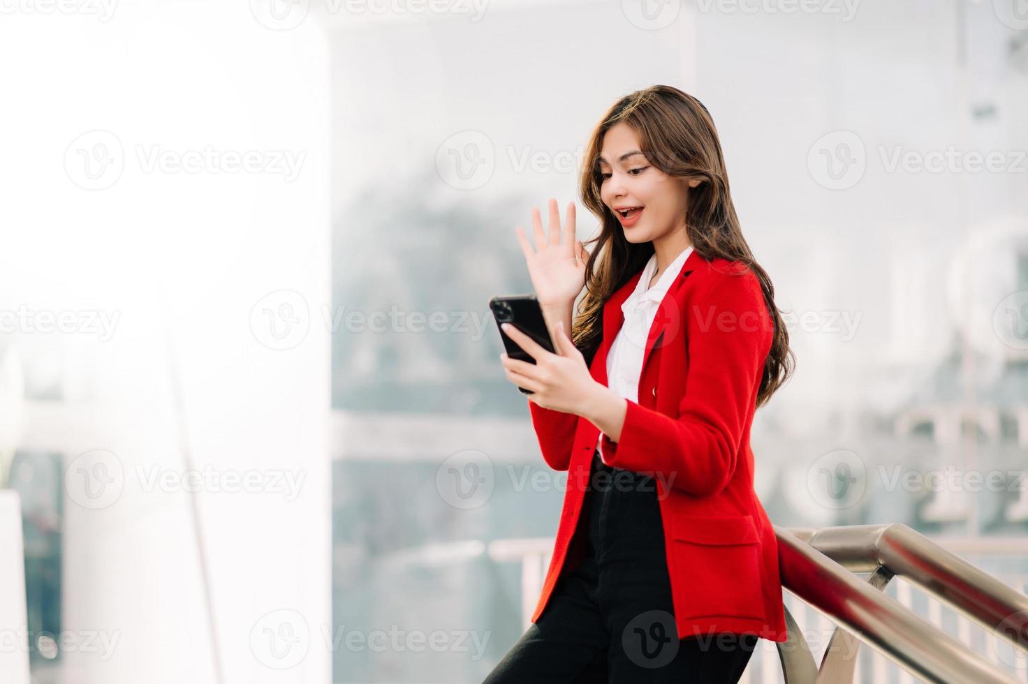 donna d'affari concetto un' femmina manager frequentando video conferenza e Tenere tavoletta, smatrphone e tazza di caffè su strada nel città al di fuori ufficio foto