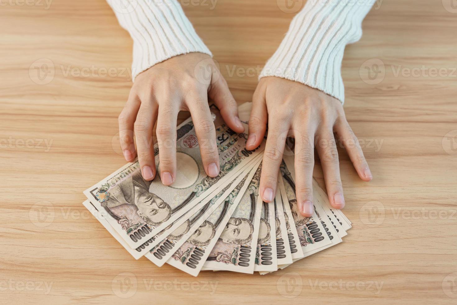 donna mano conteggio giapponese yen banconota al di sopra di tavolo sfondo. mille yen i soldi. Giappone Contanti, imposta, recessione economia, inflazione, investimento, finanza, risparmio, stipendio e pagamento concetti foto