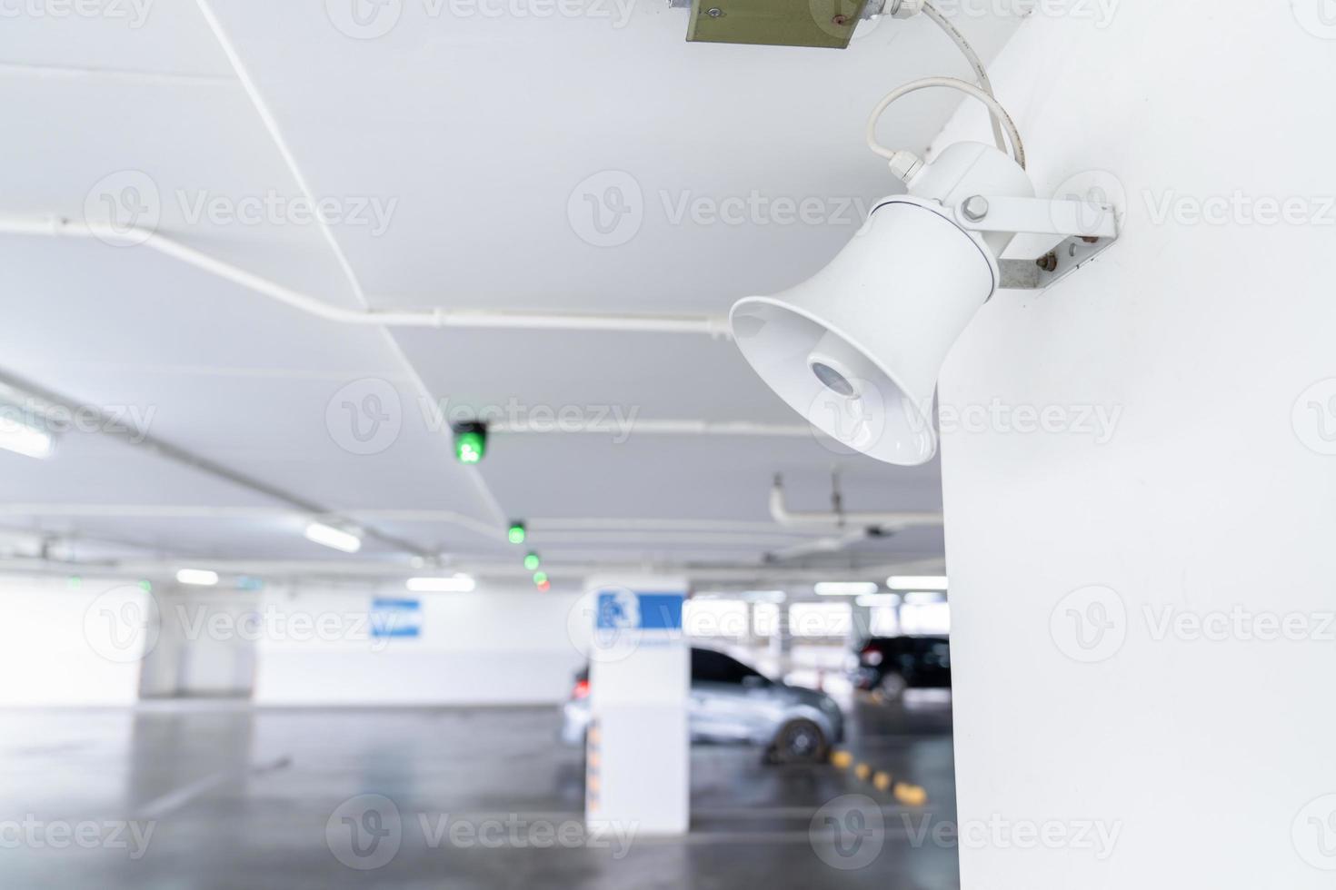 un' megafono altoparlante è impostato su su il polo soffitto nel auto parcheggio la zona. foto