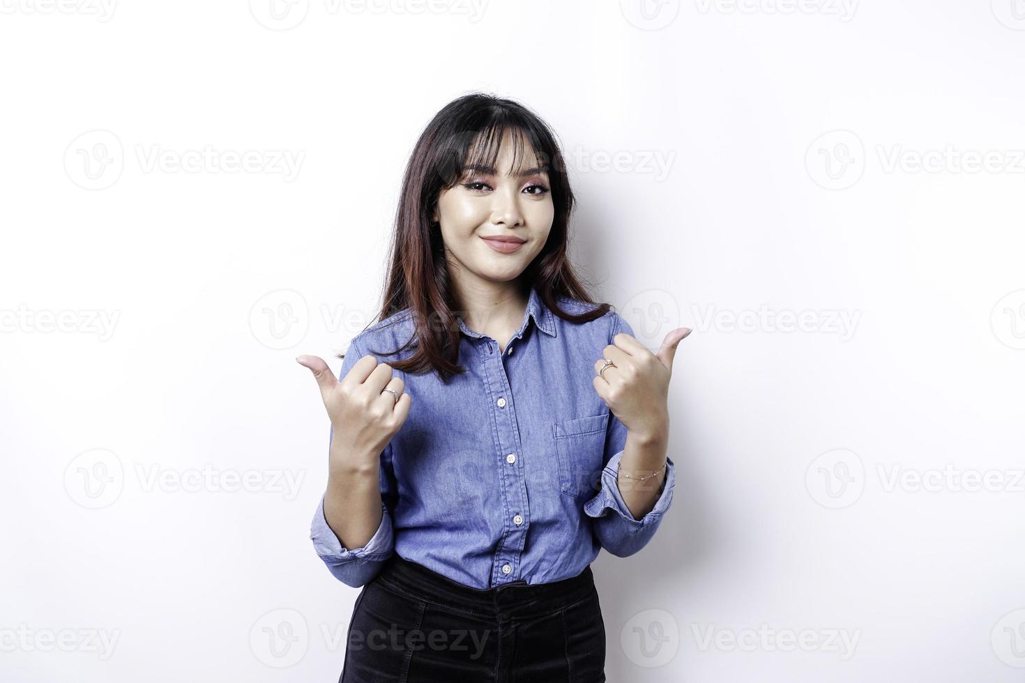 eccitato asiatico donna indossare blu camicia dà pollici su mano gesto di approvazione, isolato di bianca sfondo foto