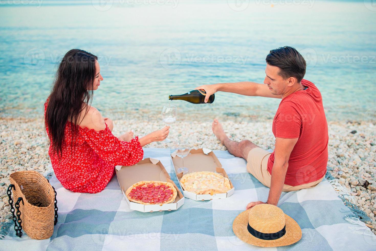 bello giovane coppia avendo un' picnic a il spiaggia foto