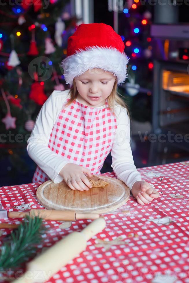 adorabile poco ragazza con rotolamento perno cottura al forno Pan di zenzero biscotti per Natale foto