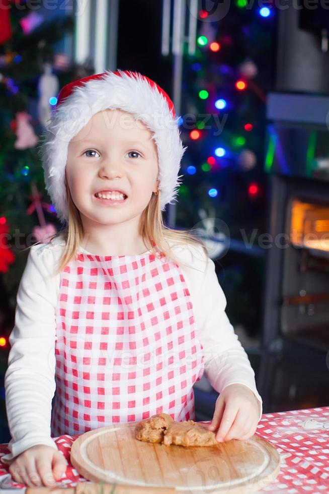 ritratto di contento carino poco ragazza nel il cucina cottura al forno Pan di zenzero foto