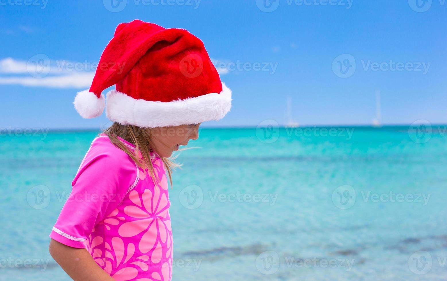 poco adorabile ragazza indossare Santa cappello a tropicale spiaggia foto