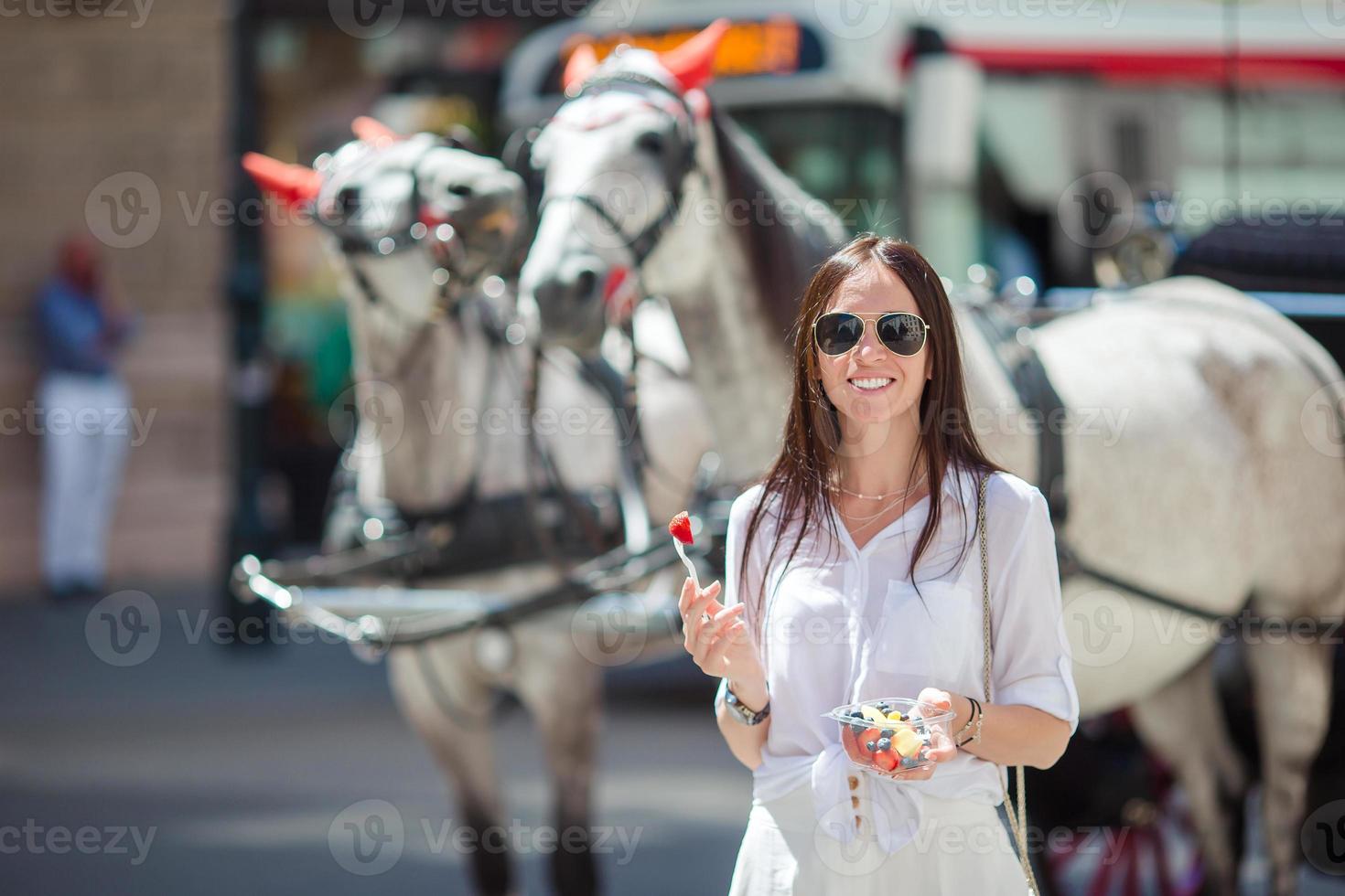 turista ragazza godendo un' passeggiare attraverso vienna e guardare a il bellissimo cavalli nel il carrozza foto