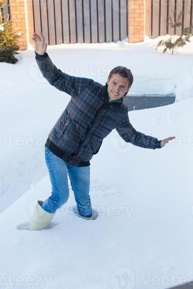 giovane uomo nel inverno stivali abbattere in un' in profondità bianca neve foto