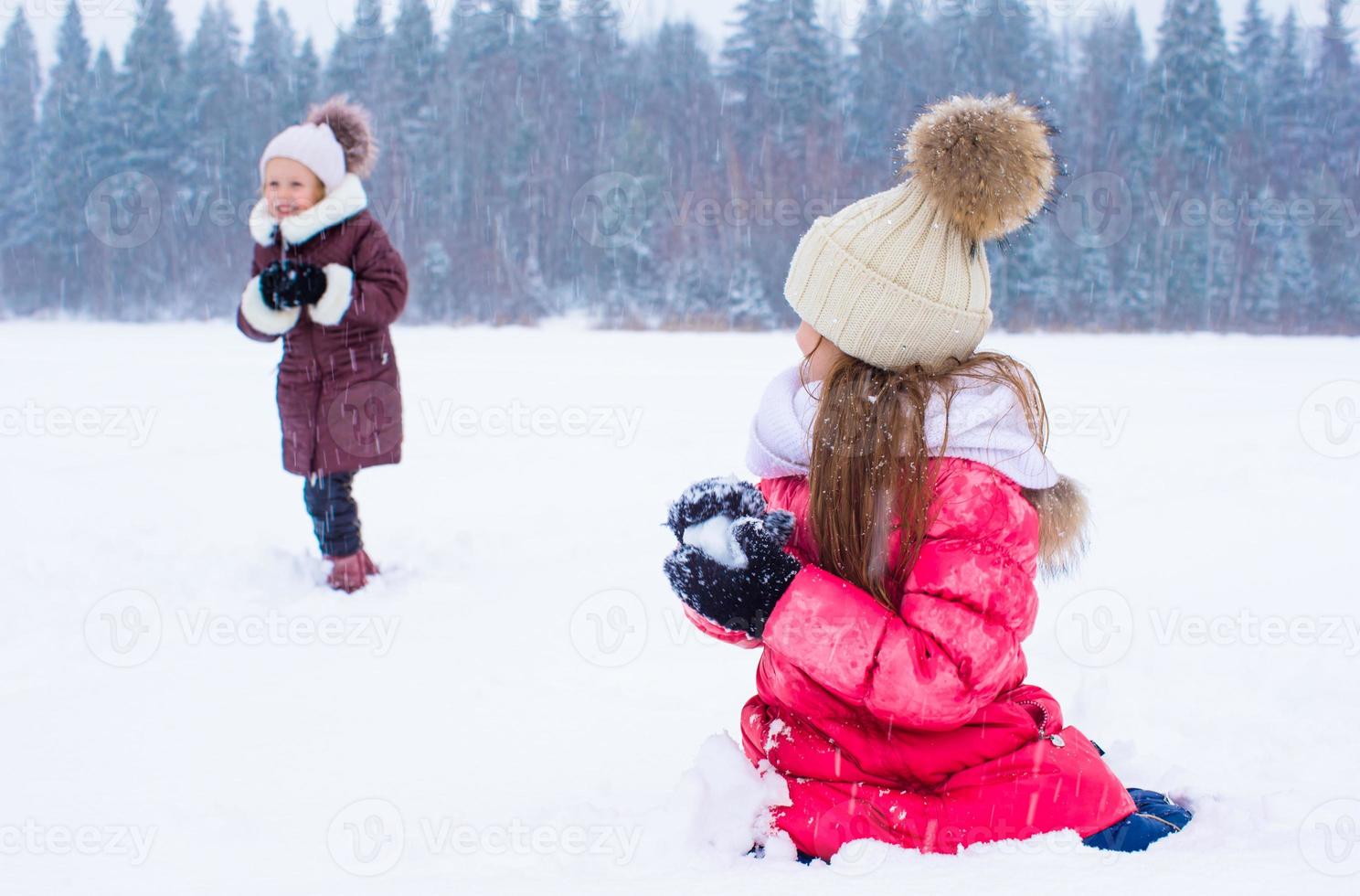 adorabile poco ragazze all'aperto su inverno neve giorno foto