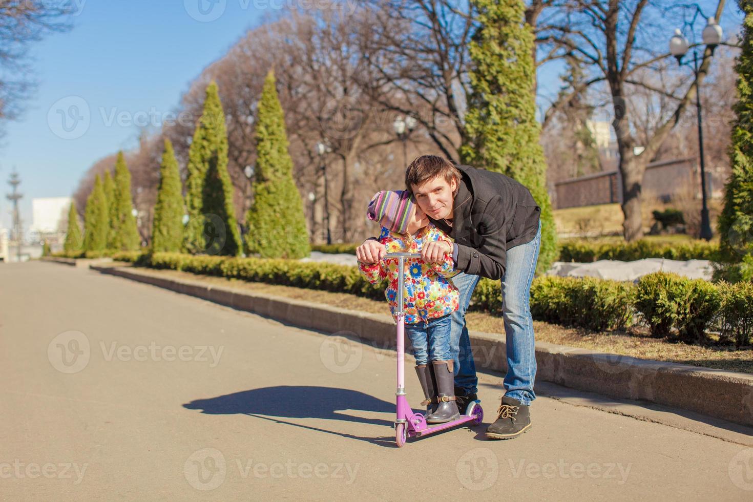 adorabile poco ragazza e contento padre cavalcata su scooter a soleggiato giorno foto